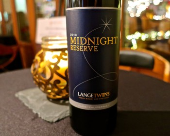 Lodi Midnight Reserve wine bottle from Langetwins, 2013 vintage, on a table with decorative candle holder.
