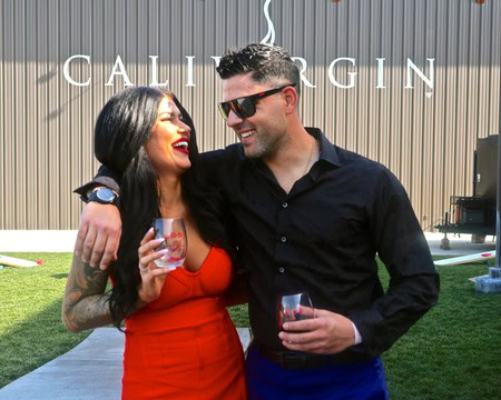 Two people enjoying wine at a Lodi Winegrape Commission event outdoors.