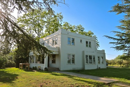 Contemporary white house surrounded by lush greenery in Lodi wine region, California.