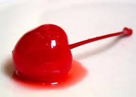 Close-up of a shiny red cherry with a long stem on a white background.