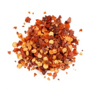 Close-up of a spicy seasoning mix with chili flakes, mustard seeds, and herbs for wine pairing.