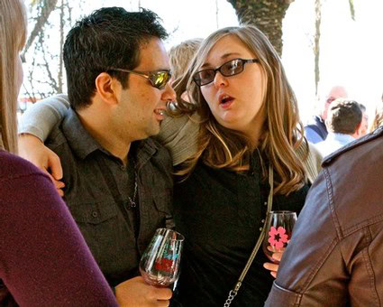 People enjoying wine tasting outdoors at a Lodi Winegrape Commission event.