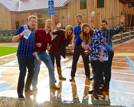 Group of friends celebrating outdoors with drinks at Lodi Winegrape Commission event.