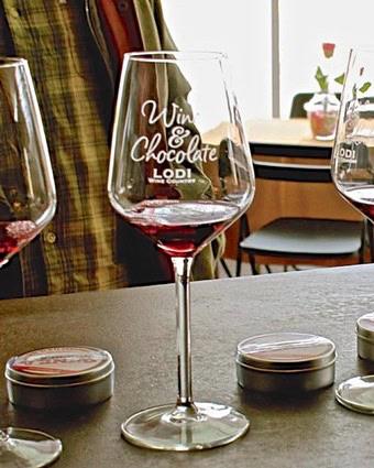 Wine glass with red wine and Lodi Winegrape Commission logo for SEO.