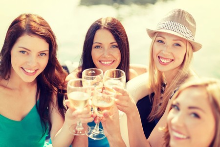 Group of women enjoying wine, smiling, and toasting with glasses outdoors, promoting Lodi wine culture.