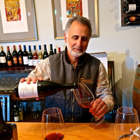 Man pouring red wine into a glass at a wine tasting event in Lodi, California.