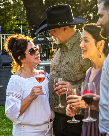 Group of people enjoying wine tasting outdoors at a Lodi wine event.