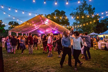 People dancing and enjoying a festival under string lights at an outdoor event in Lodi, California.