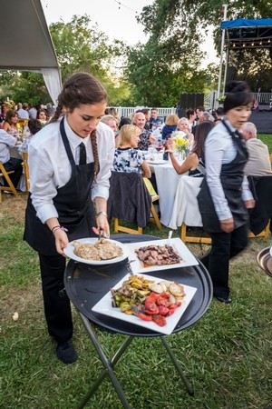 Waitstaff serving food at an outdoor event organized by Lodi Winegrape Commission.