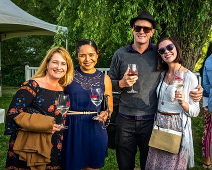 Group of four people enjoying wine tasting outdoors at a Lodi wine event.