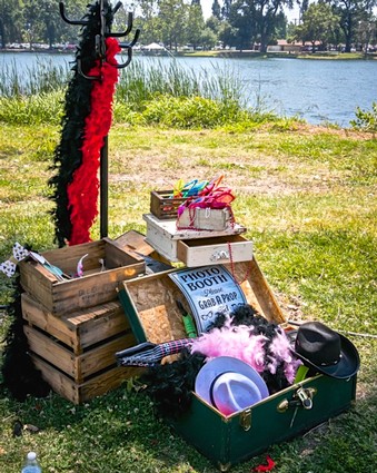 Outdoor event setup with crates, props, and decorations near a lake for Lodi Winegrape Commission.
