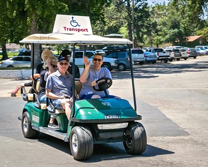 Golf cart with people enjoying a sunny day at Lodi Winegrape Commission event.