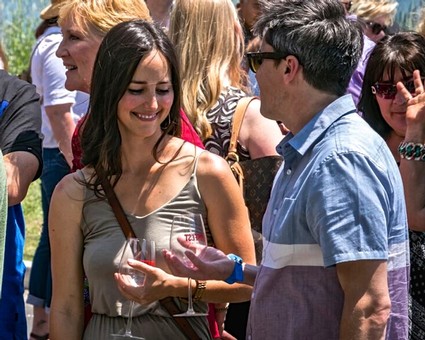 People enjoying wine tasting at a Lodi Winegrape Commission event outdoors.