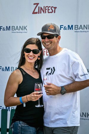 Smiling man and woman holding wine glasses at Lodi Winegrape Commission event.