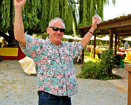 Smiling man in floral shirt celebrating outdoors at Lodi Winegrape Commission event.