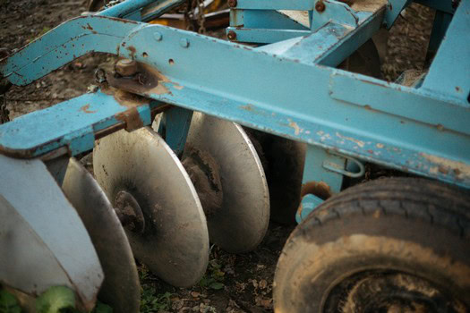 Close-up of blue vineyard equipment used for soil preparation in Lodi winegrape vineyards.