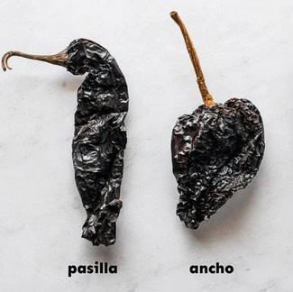 Dried Pasilla and Ancho chili peppers on a white background for culinary use.