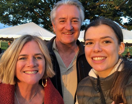 Smiling family at Lodi Winegrape Commission event with tents and trees in background.