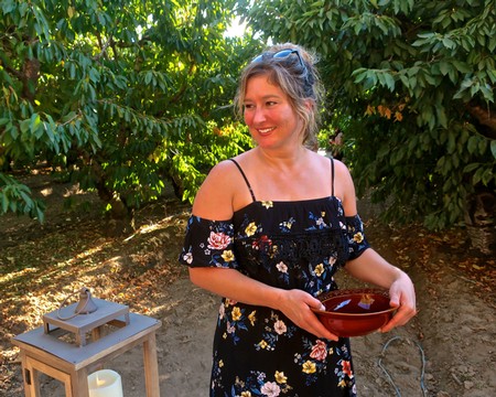 Woman holding a bowl at a Lodi Winegrape Commission event in a vineyard setting.