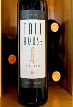2012 Tall House Vineyards Lodi wine bottle with label and wooden background.