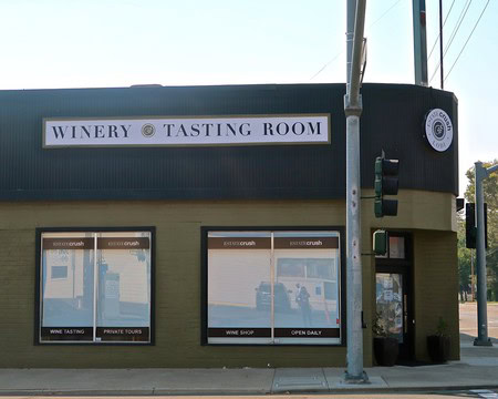 Exterior view of the Lodi Winegrape Commission winery tasting room with signage and large windows.