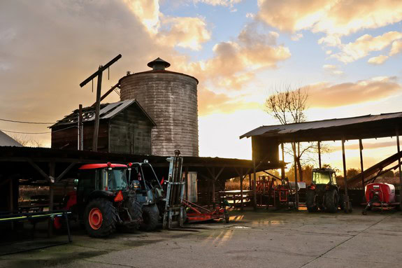 Farming equipment at Lodi Winegrape Commission during sunset, showcasing vineyard operations.