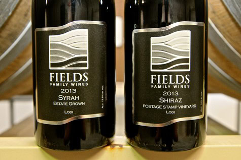 Two bottles of Lodi wine from Fields Family Wines, Syrah and Shiraz, vintage 2013, on display in a wine store.