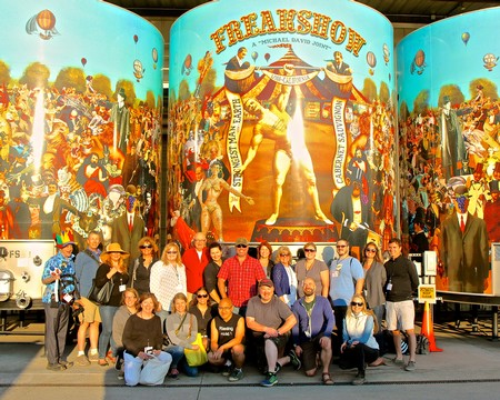 Group of people at Lodi Winegrape Commission Freakshow event with colorful circus-themed backdrop.
