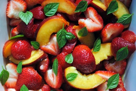 Close-up of fresh strawberries, peaches, and basil leaves, highlighting Lodi's fruit harvest and winegrape quality.