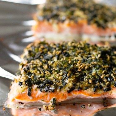 Fresh salmon fillet topped with a herb and seed crust, ready for baking or serving.