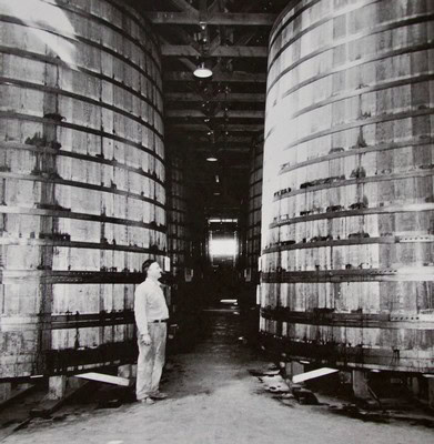 A person inspecting large wine fermentation tanks at a winery in Lodi, California.