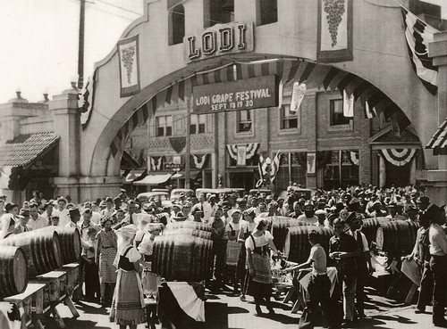 Vintage black and white photo of the Lodi Wine Festival with crowds and wine barrels.