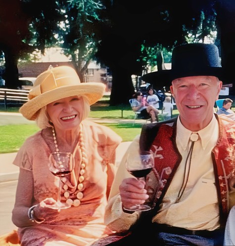 Elderly couple enjoying wine at Lodi Winegrape Commission event outdoors.