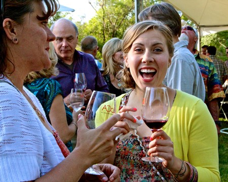 People enjoying wine tasting at a Lodi Winegrape Commission event outdoors.