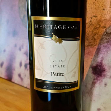 Heritage Oak Petite 2016 wine bottle from Lodi Winegrape Commission, featuring a black and gold label with estate and appella.
