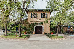 Historic building of the Lodi Winegrape Commission surrounded by trees in a scenic setting.