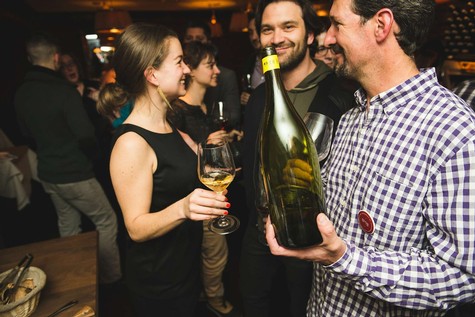 People enjoying wine tasting at a Lodi Winegrape Commission event with smiles and wine glasses.