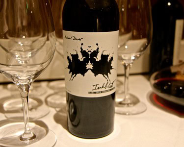 Close-up of a wine bottle labeled 'Turbulence' surrounded by wine glasses on a table.