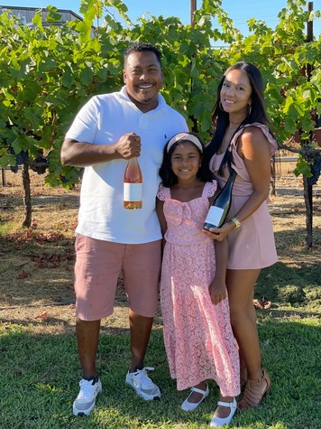 Family enjoying wine tasting at Lodi vineyard, showcasing grapevines and wine bottles for SEO.