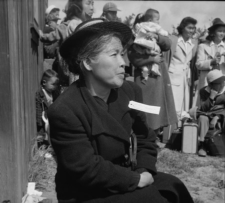 Black and white photo of a woman in a hat at a Lodi wine event with a crowd in the background.