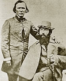 Vintage photo of two Lodi winegrowers, one standing and one seated, with traditional attire and a beard, from the early 20th.