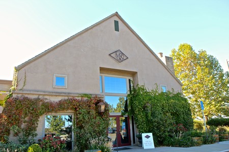 Exterior view of the Lodi Winegrape Commission building with lush greenery and clear sky.