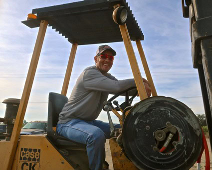 Farmer operating a forklift in a vineyard, promoting Lodi winegrape production and quality.