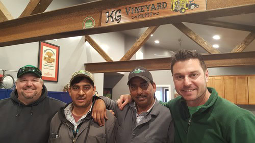 Group of four men smiling indoors at Lodi Winegrape Commission event.