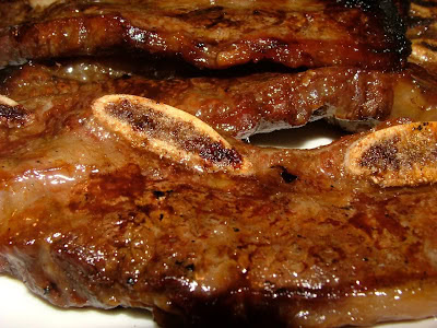 Close-up of grilled meat with caramelized bananas, highlighting food quality and preparation.