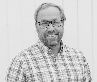 Portrait of a smiling man with glasses and a checkered shirt, representing Lodi Winegrape Commission.