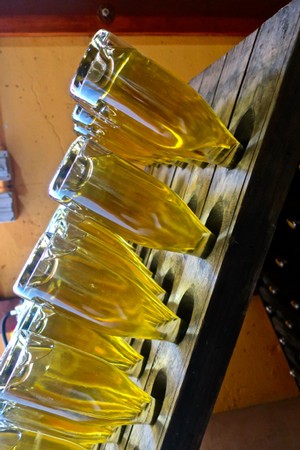 Multiple wine glasses filled with white wine on a wooden display at Lodi Winegrape Commission event.