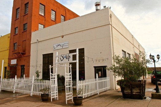 Exterior view of the Lodi Winegrape Commission building with white fence and string lights in Lodi, California.