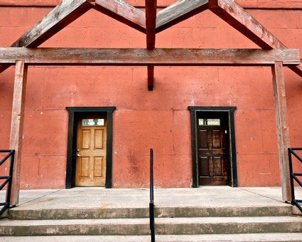 Two wooden doors on a red brick building with steps and black railings, representing Lodi wine industry history.