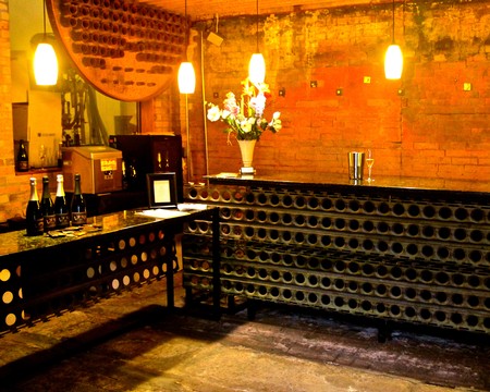 Wine cellar with brick walls, wine bottles, and decorative lighting for Lodi wine tasting events.